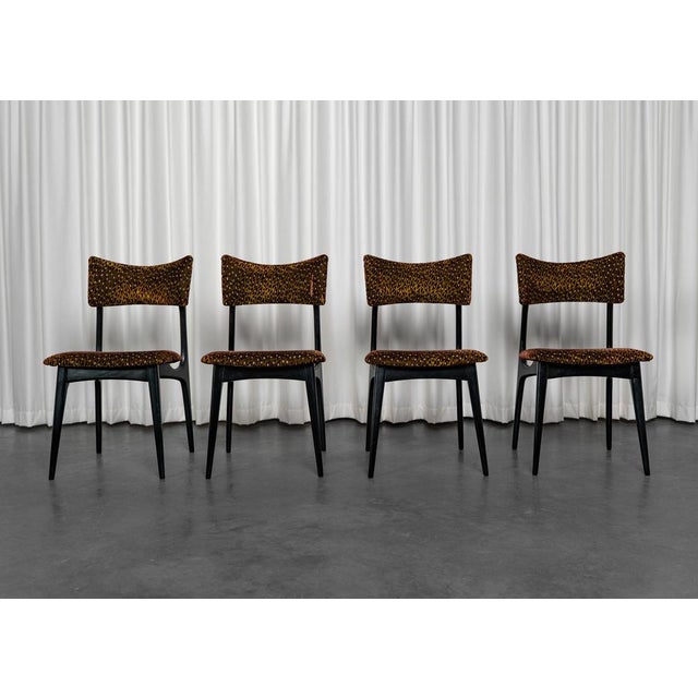 Set of four modernist chairs in the style of Alfred Hendrickx. These chairs have black lacquered legs and have been...
