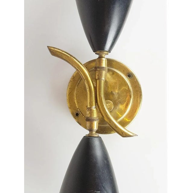 This decorative 2-light sconce was produced around the 1950s. It is made from 2 adjustable painted aluminum shades joined...