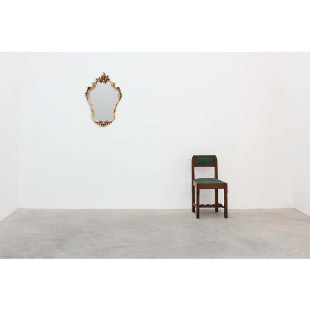 An elegant Italian Rococo Revival wall mirror crafted during the 20th century, featuring a richly sculpted cream-painted...