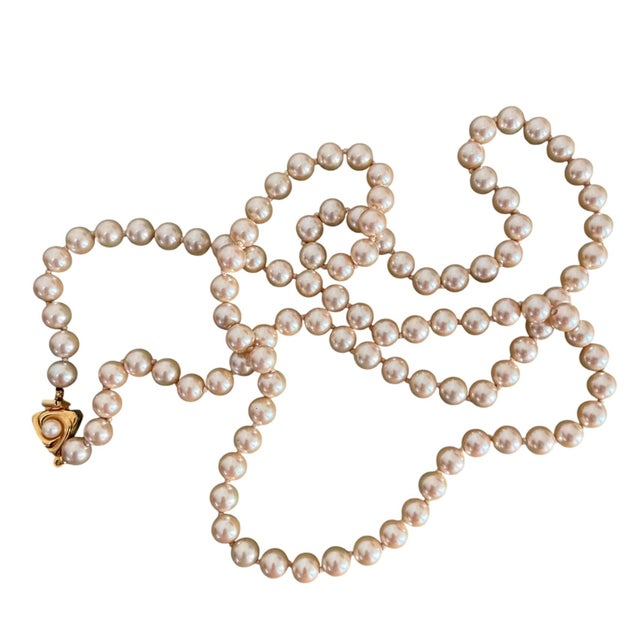 A great 1980’s cultured pearl necklace featuring a distinct gold-toned stylized clasp. Clasp: The gold clasp has a unique,...