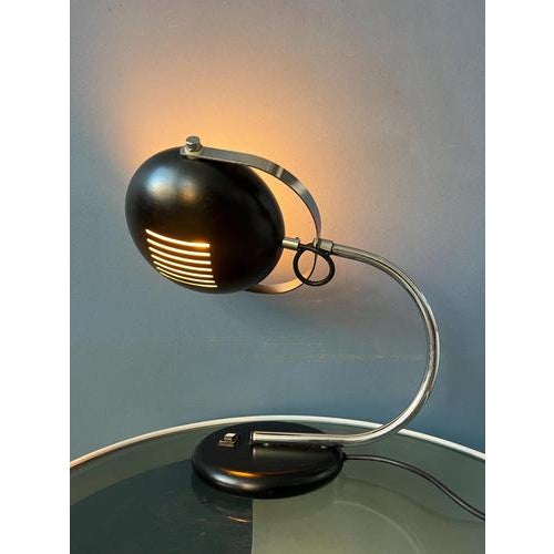 Brown space age table lamp with beautiful roster-like shade. The metal shade can be turned up and down. The bracket that...