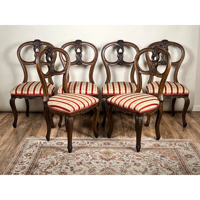 A charming suite of six Centennial Victorian style balloon-back dining chairs in walnut, dating to the mid-20th century,...