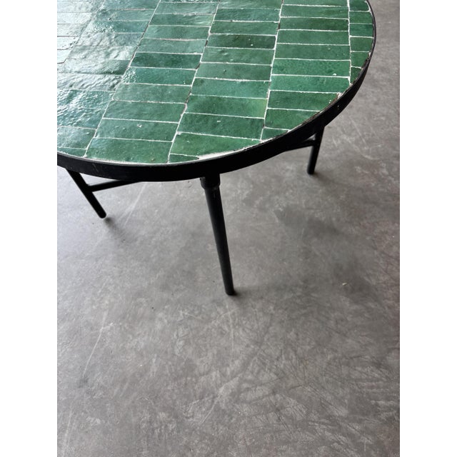 Round coffee table handcrafted in Morocco using traditional zellige techniques. The tabletop is composed of individually...
