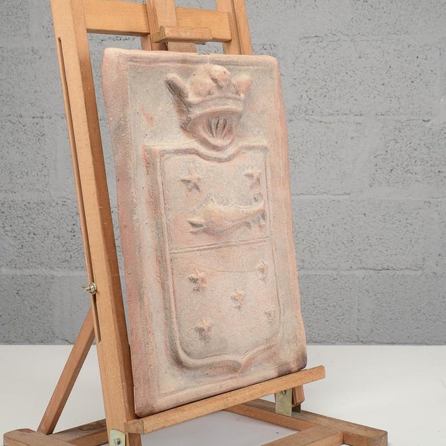 This elegant decorative terracotta plaque depicts a heraldic coat of arms of great historical and decorative charm....