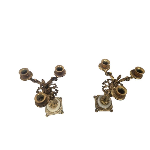 Ornate matching pair of vintage three-light candelabras featuring scrolling foliate arms, beaded candle cups and classical...