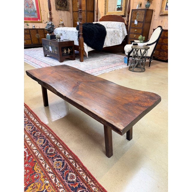 A distinguished vintage coffee table showcasing the natural beauty and character of solid wood. Featuring a substantial...
