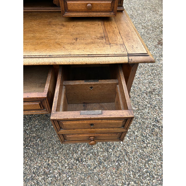 Rich in character and charm, an antique weathered French Oak writing desk having stepped back with multiple little drawers...