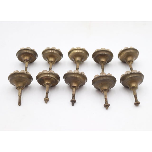 Antique cabinet or drawer knobs made of clear sandwich glass fronts and pressed brass backings. Good condition with...