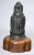 Stone bust of Bodhisattva with serenely carved features and elaborate coiled coiffure with carved Buddha headdress set...