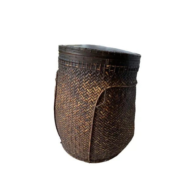 This mid-20th century hand-woven basket originates from the Dayak tribe of Borneo crafted with rattan fibres and an...