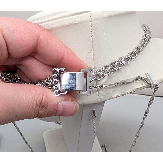 Rhodium plated 3-strand with a Victorian look floral pocket watch style (it does not open up) pendant with necklace fold...