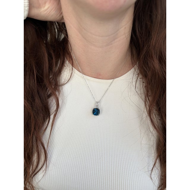 This beautiful pendant features a 9.39 carat London Topaz gemstone with natural earth mined diamonds. This pendant makes a...