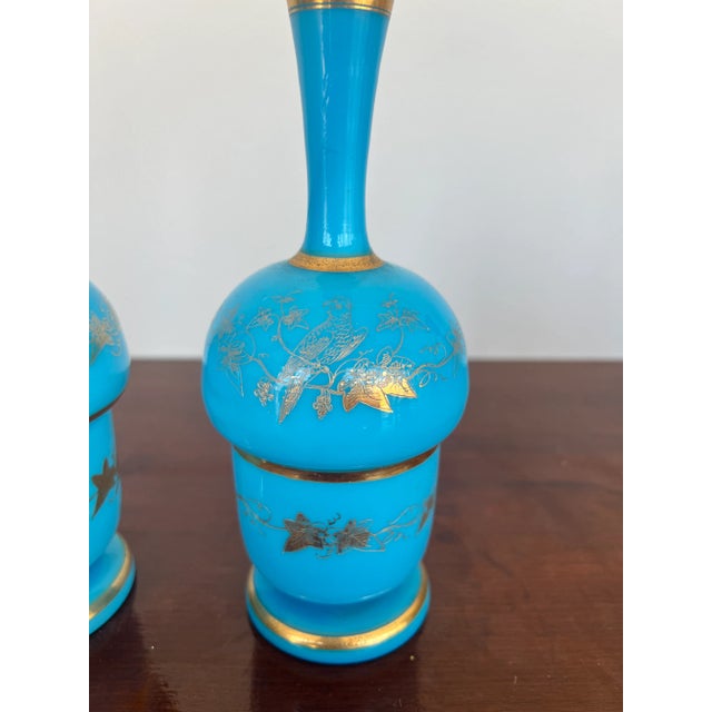 French, 20th century. A pair of blue opaline bud vases with gold foliate and vine decoration.