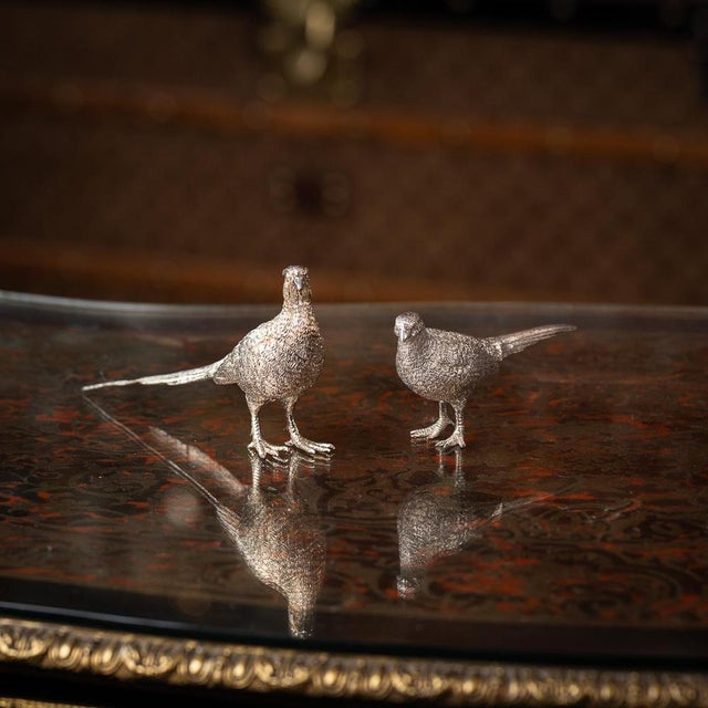 A superb 20th century english solid silver pair of pheasant salt and pepper shakers. Modelled as male and female...