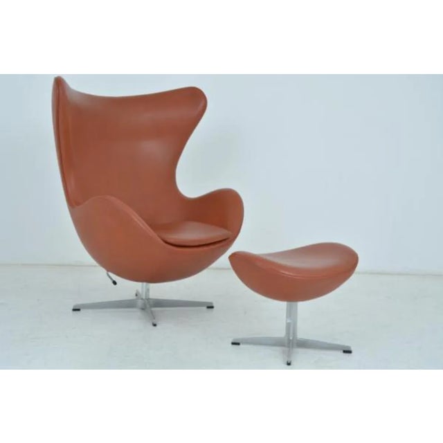Egg armchair and footrest by Arne Jacobsen Edited by Fritz Hansen. DENMARK Stamped in the mass of the base. Seat tilt...