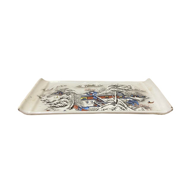 This is an oriental Chinese decorative plate with a distressed off white base and oriental snow trees house scenery...