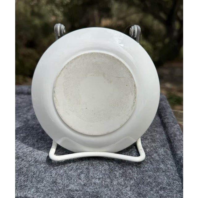 A vintage Trader Vic's porcelain ashtray featuring whimsical, mid-century illustrations of Hawaiian "Honi Honi" dancers...