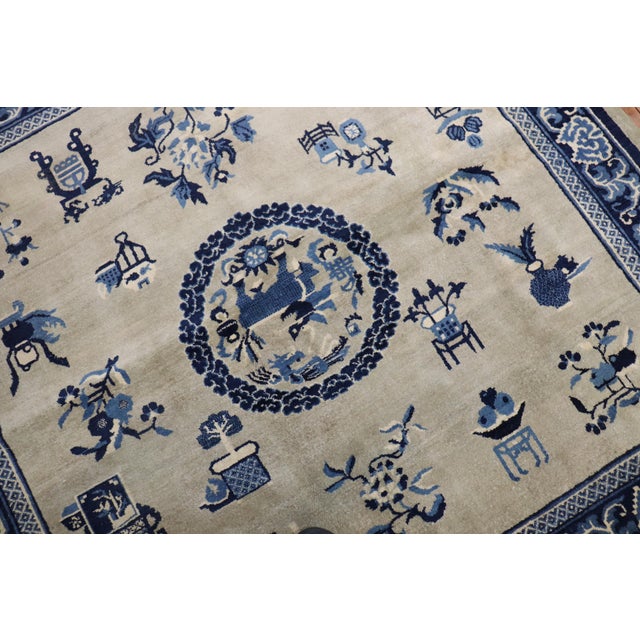 A rare 6 foot square an early 20th century Chinese rug with a graphic Chinese Motif in slate and blue Measures: 6' x 6'1".