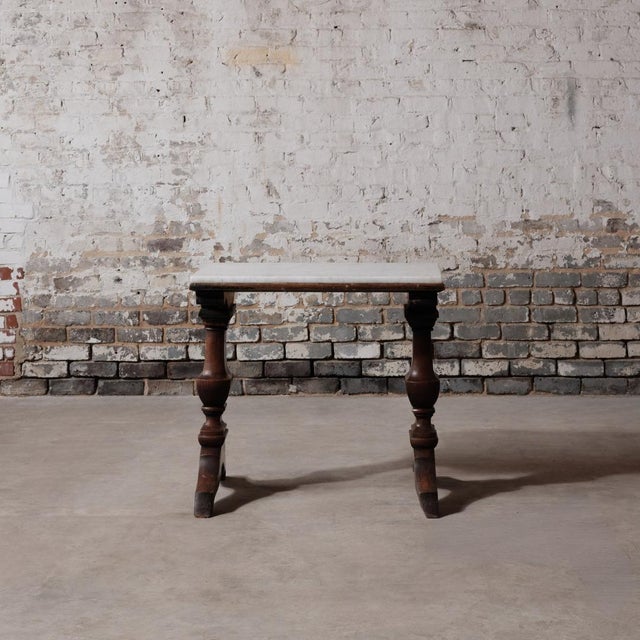 Circa 19th-century side table crafted from walnut and topped with white marble. With its classic proportions and warm...