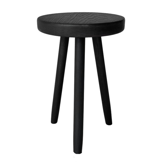 An oak wood stool made out of solid wood and stained in an almost-black with graining showing through. The stool is...
