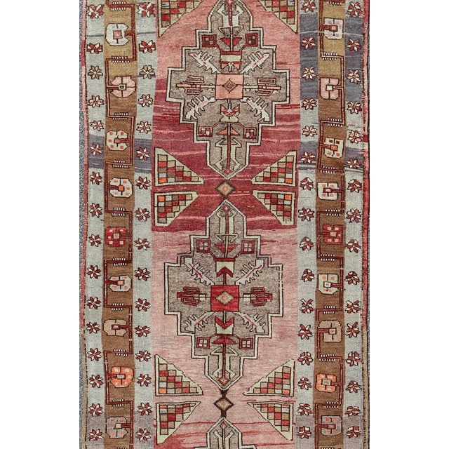 Measures: 4'2 x 14'0. This vintage Oushak runner contains a unique blend of cheerful colors and an intricately beautiful...