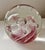 Beautiful round clear glass paperweight with a soft pink and white swirl inside. Small controlled bubbles float around a...