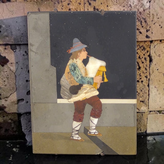 The Antique Italian Art Pietra Dura Plaque featuring a bagpipe musician is a handmade mosaic plaque crafted from stone....