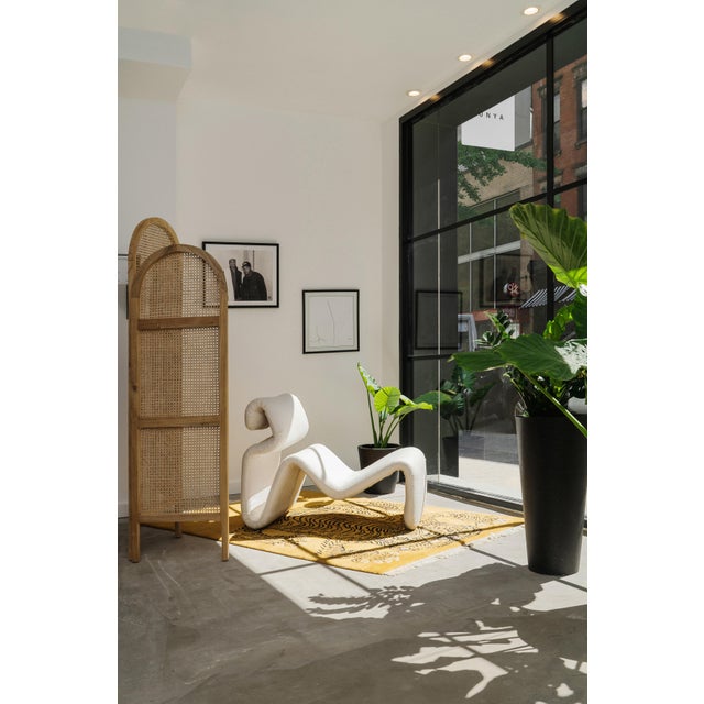 Striking sculptural chaise lounge with matching ottoman, upholstered in a soft cream linen. Defined by its fluid,...