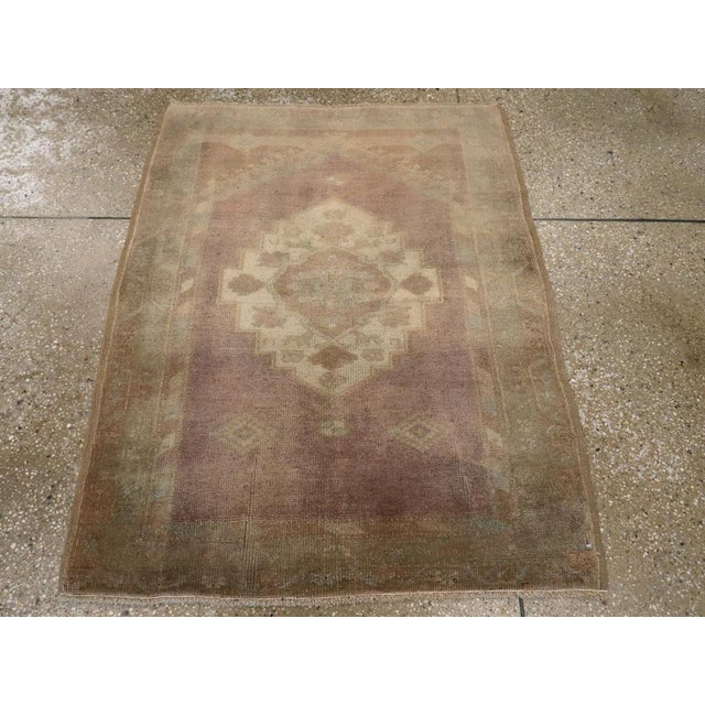 This early 20th century Turkish Oushak rug, measuring 2' 11" x 3' 8", features the soft, atmospheric palette and spacious...