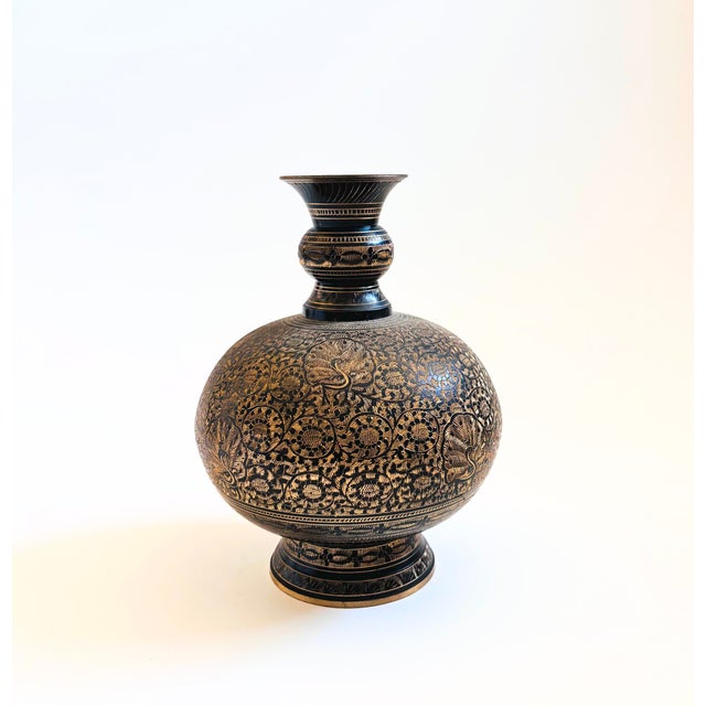 A vintage brass vase with an intricate etched floral design with peacocks to the surface. Black finish with the etched...