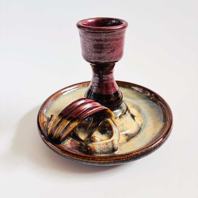 A vintage studio pottery candle holder. Features a multicolored glaze in purple, blue, and earth tone colors. Beautiful...