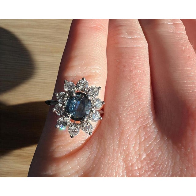 Vintage Daisy Ring from the 1990s, made in 18 Carat White Gold (750 thousandths). The ring is set with a natural oval-...