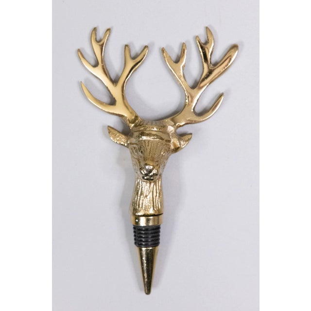 A stylish vintage set of gold tone metal barware tools including a bottle opener and stopper with stag head handles. These...