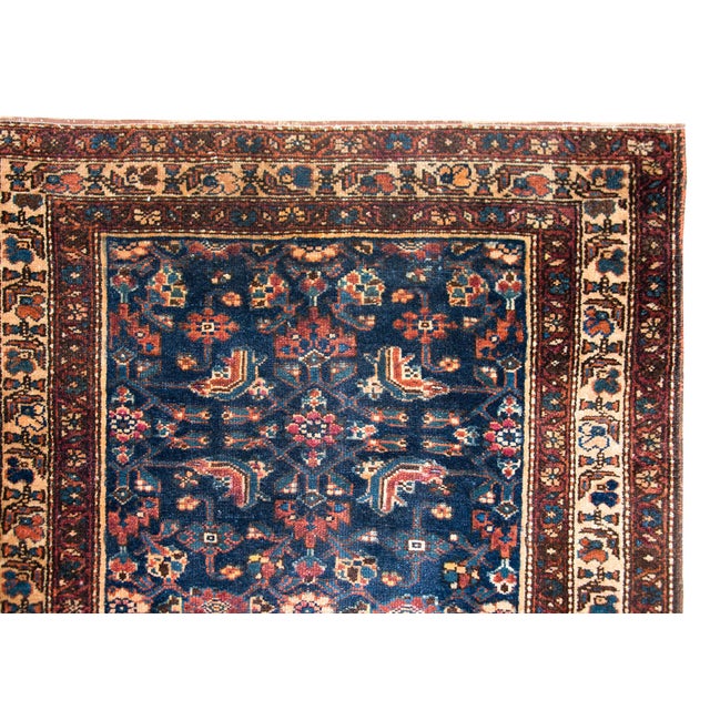 A remarkable early 20th century Persian Kurdish rug with an all-over mirrored trellis floral pattern surrounded by a...