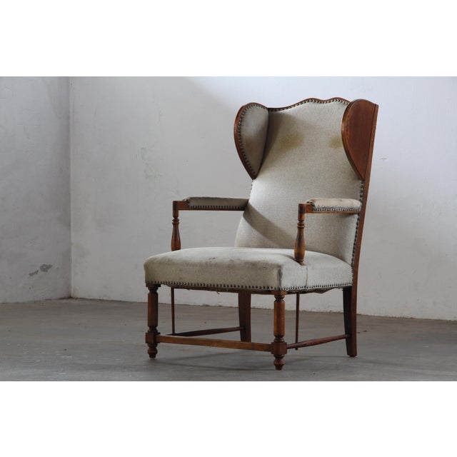 This exceptional vintage wingback armchair, requiring new upholstery, presents a compelling opportunity to restore a...