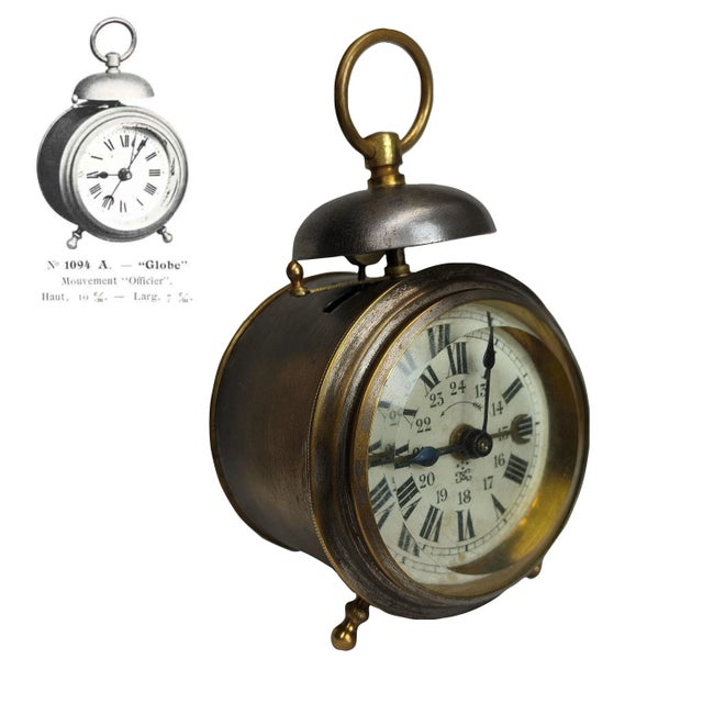 French alarm clock named Globe. This rare clock has a nickel-plated brass case. The clock face displays Roman and Arabic...