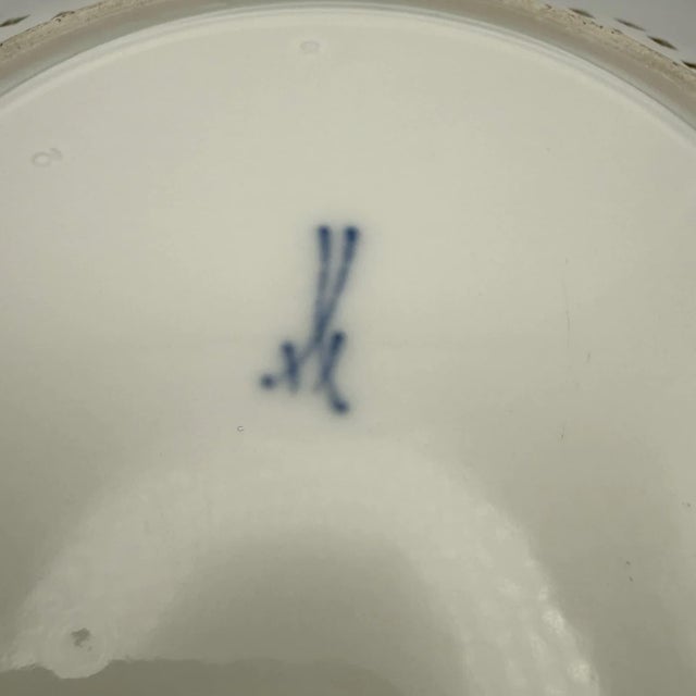 This plate is distinguished by its intricately crafted openwork rim and the timeless "onion pattern" decoration in...