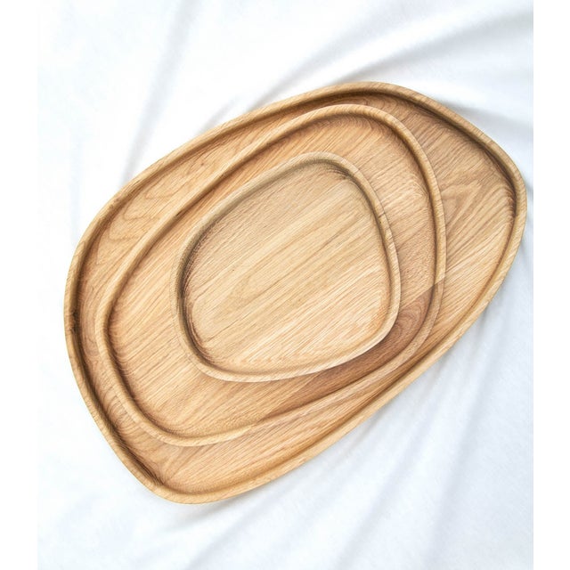 A sculptural set of three solid oak bowls that bring together form and function. The smooth, organic shapes are inspired...
