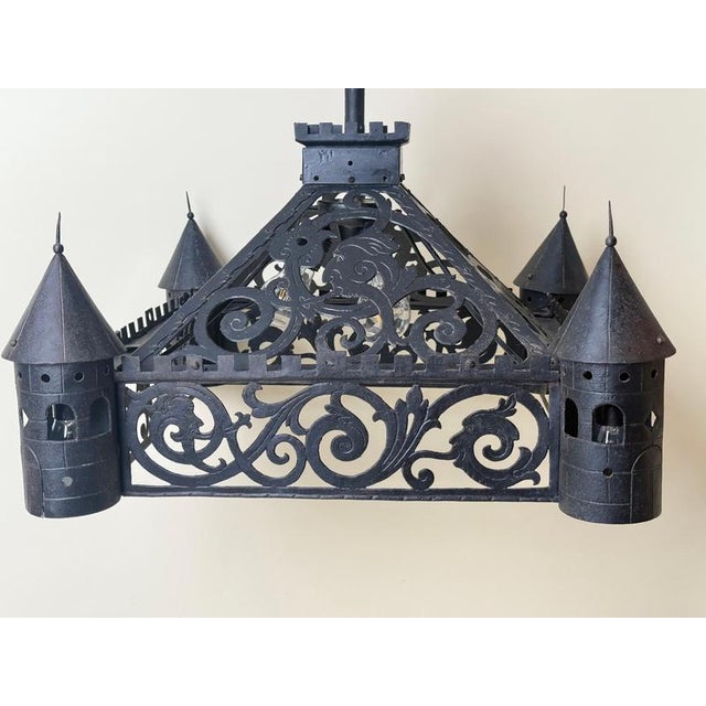 An antique gothic revival wrought iron chandelier with a highly architectural castle-like form, four turret sections,...