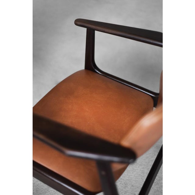 This modernist office chair was made in Denmark during the 1960s. The elegant frame is made of mahogany wood in a shade of...