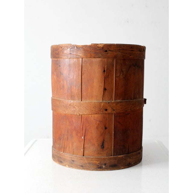 This antique wood barrel features traditional stave construction with wooden hoops and early fasteners. A rich, timeworn...