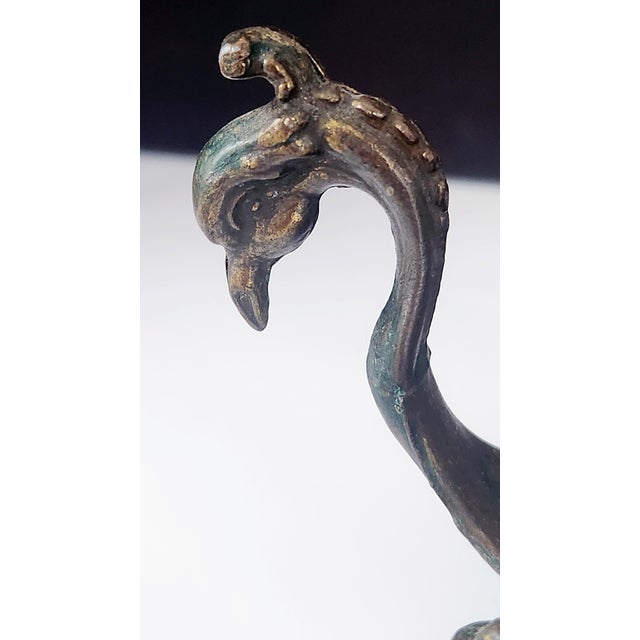 A late 19th-century antique brass chamberstick candle holder featuring Rococo Revival scrollwork and a gracefully...