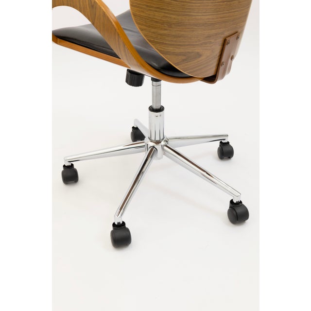This retro inspired office chair combines a molded wood shell with smooth black leather upholstery for a clean modern...