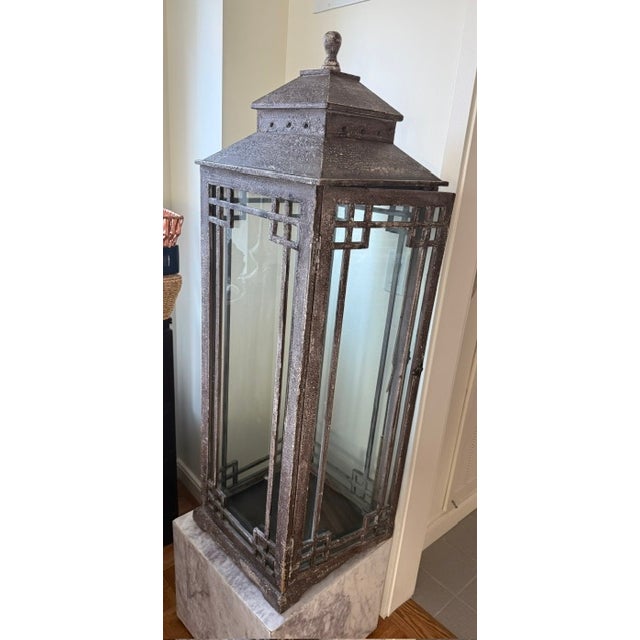 Make a statement with this dramatic floor lantern, blending rustic farmhouse charm with a sleek geometric silhouette....