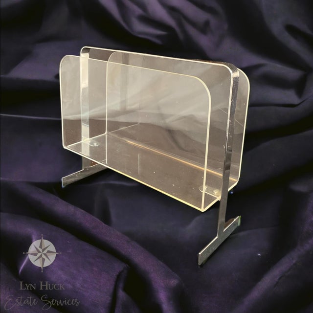 Mid-Century Magazine Rack of Lucite and Chrome Discover this cool magazine rack made of shiny chrome and clear Lucite....