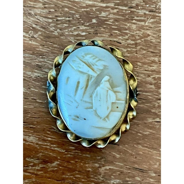 This vintage Victorian scenic cameo brooch presents a finely hand-carved figural scene in soft blue-gray hardstone,...