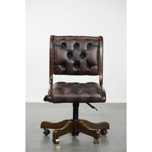 Luxurious and elegant English-style Chesterfield office chair made of cowhide and wood, on casters. : This luxurious brown...