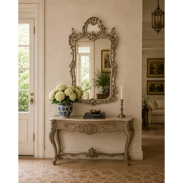 An exceptional late 20th century French Louis XV silvered giltwood mirror with richly carved Rococo detailing and a...
