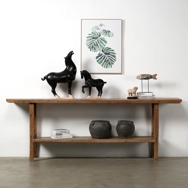This extra-long vintage console table features a slender profile with an integrated lower shelf, offering both visual...