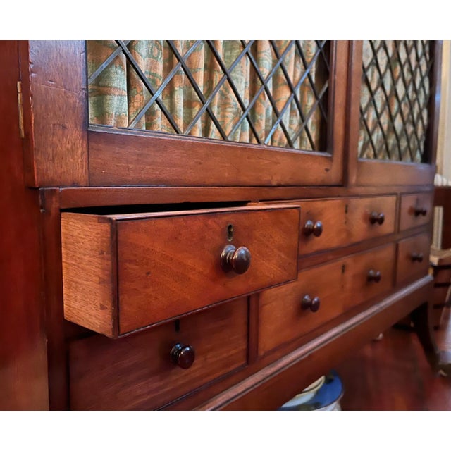 Antique 19th century English Regency dwarf bookcase cabinet. A set of small drawers rising above sabre legs with casters....